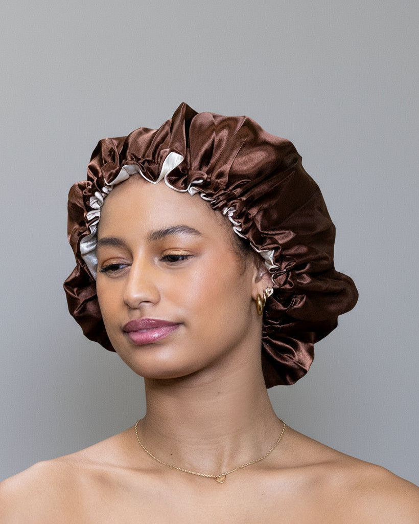 Woman wearing a brown satin bonnet against grey background