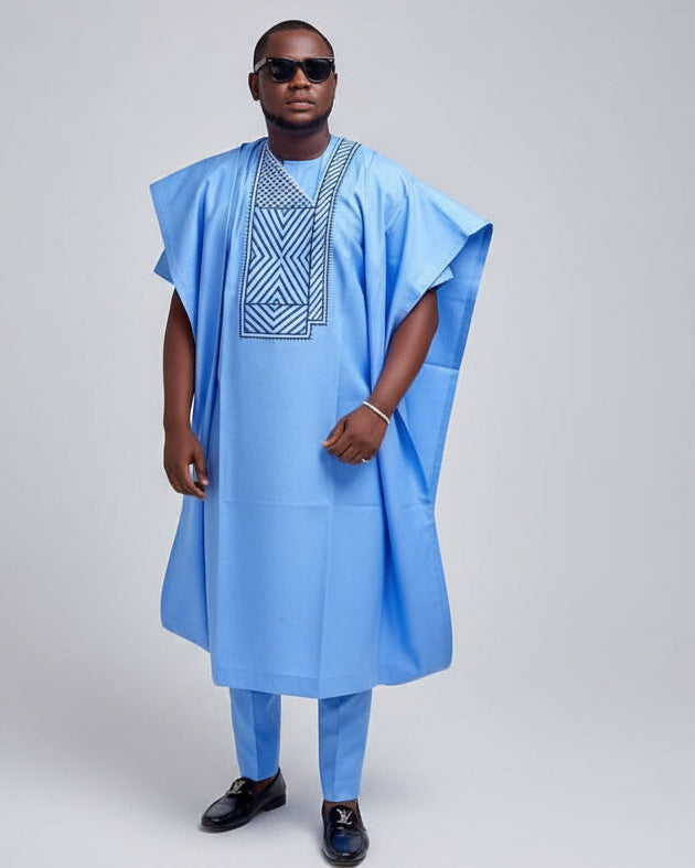 Man wearing a light blue traditional outfit with a white background