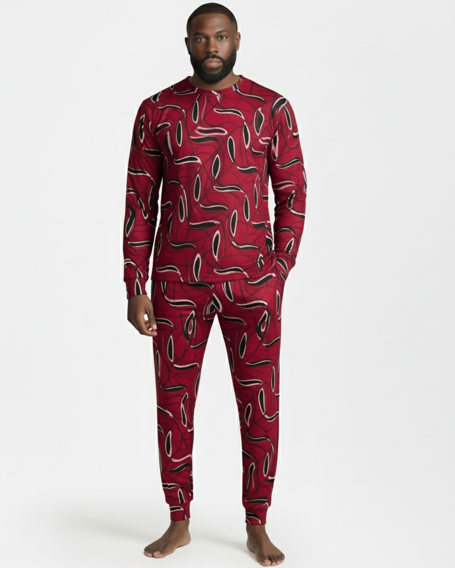 Man wearing a red patterned onesie on a grey background