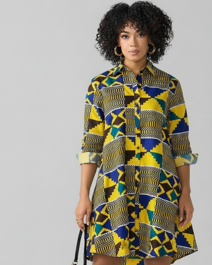 Woman wearing a colorful patterned dress with black knee-high boots on a white background