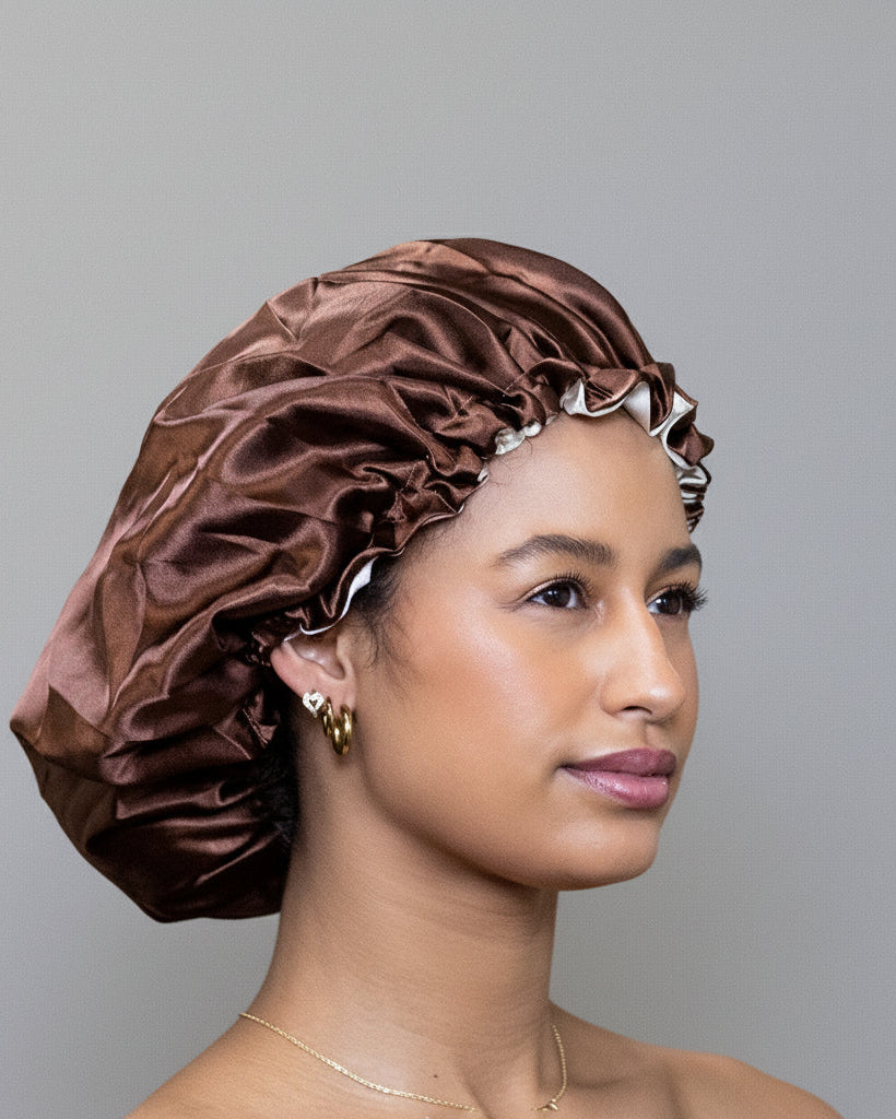 Woman wearing a brown satin bonnet against grey background