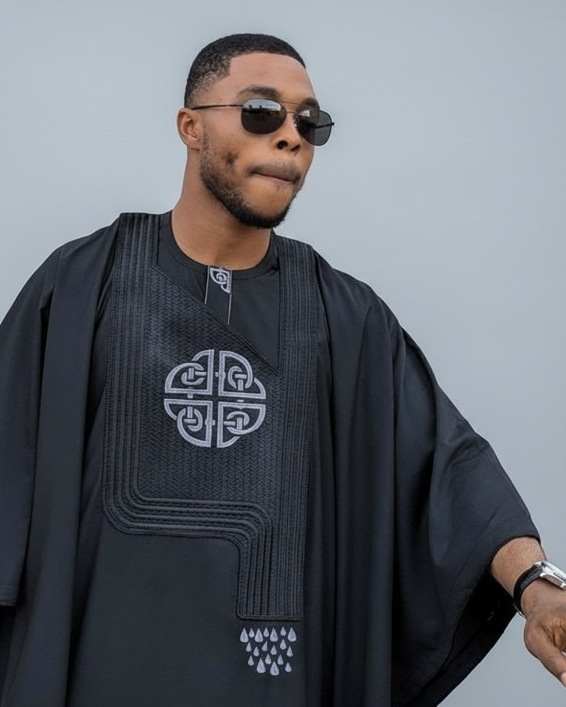 Man wearing a black outfit with a geometric design on a gray background