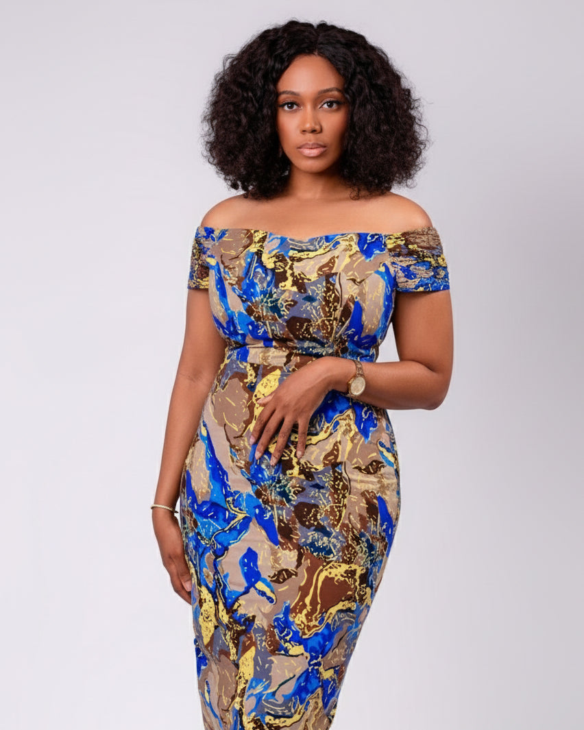 Woman wearing a colorful off-shoulder dress on a plain background