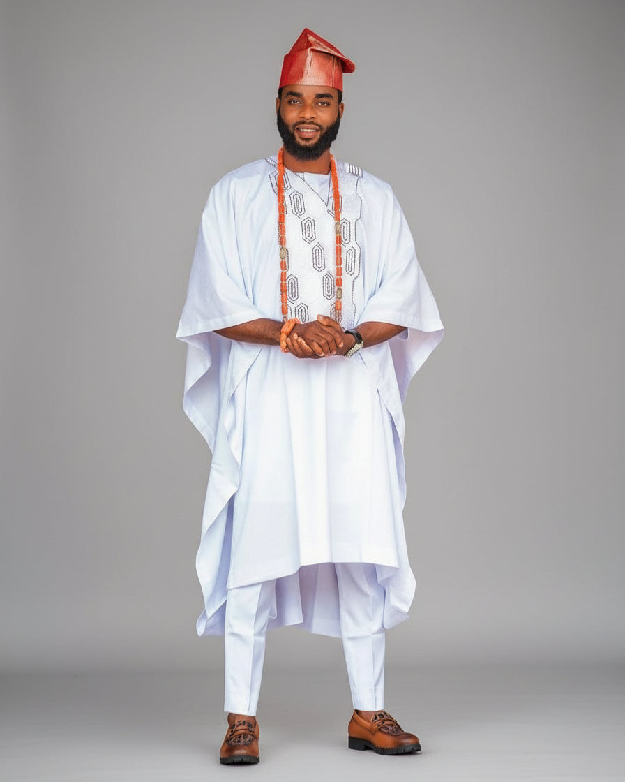 Man wearing traditional white outfit with red cap on a gray background